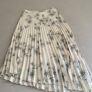 Pleated asymmetrical skirt with floral design.